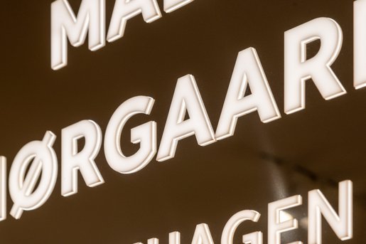 bagbelyst logoskilt i krom stål til Mads Nørgaard shop in shop i Illum
